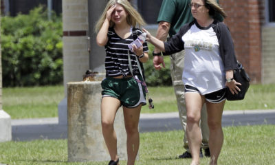 A student, left, reacts after retrieving her belongings inside Santa Fe High School in Santa Fe, Texas.