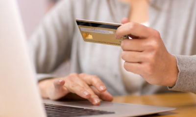 Online Sales - Woman makes credit card purchase using laptop computer
