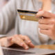 Online Sales - Woman makes credit card purchase using laptop computer
