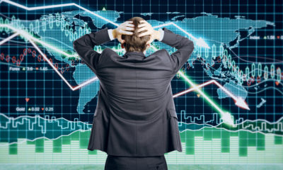 Picture of a man with his hands on head because he's puzzled by contradictory financial indicators