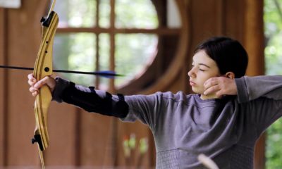 Photo of a girl scout releasing an arrow during archery session
