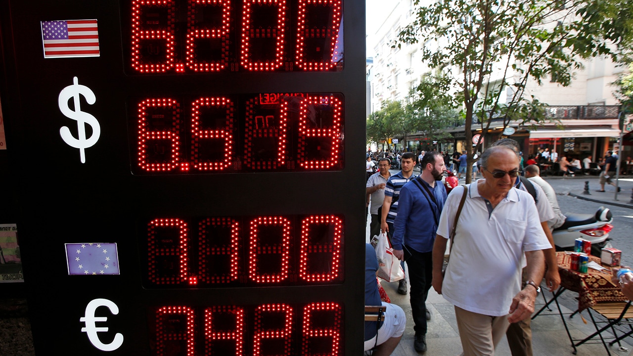 Photo of people walking past a currency exchange shop in Istanbul