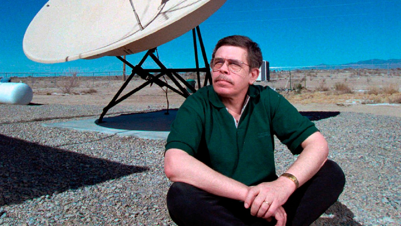 File Photo of Art Bell siting near a satellite in Nevada