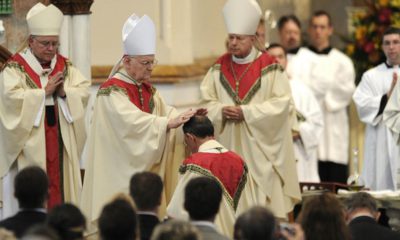 Photo of retiring bishop kneeling and praying