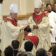 Photo of retiring bishop kneeling and praying