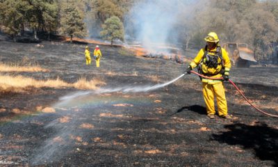 Photo of firefighters spreading water on smoldering spots