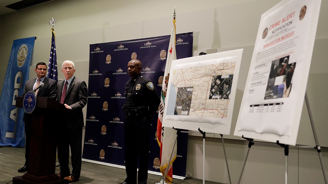 Photo of LAPD Capt. Billy Hayes fielding questions during a press conference