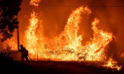 Photo of a firefighter passing through flames while battling Delta Fire