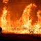 Photo of a firefighter passing through flames while battling Delta Fire