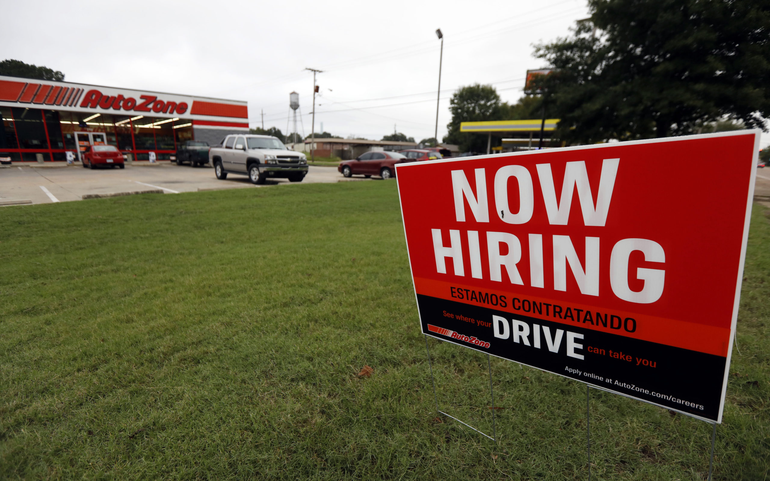 Photo of a "Now Hiring" sign in English and Spanish