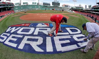 Photo of crew members painting the World Series logo at Fenway Park