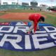 Photo of crew members painting the World Series logo at Fenway Park