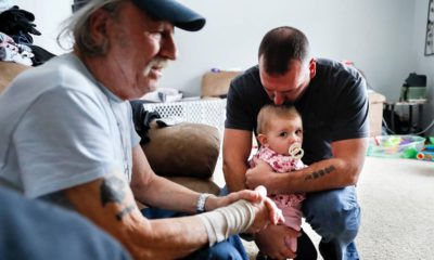 Tom Wolikow, right, holds his daughter Annabella alongside his father John