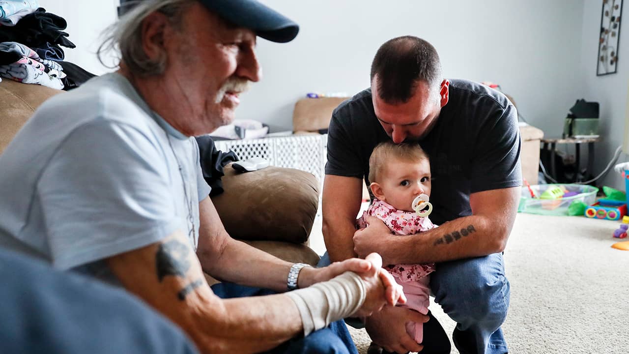 Tom Wolikow, right, holds his daughter Annabella alongside his father John