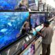 Photo of shoppers looking at televisions