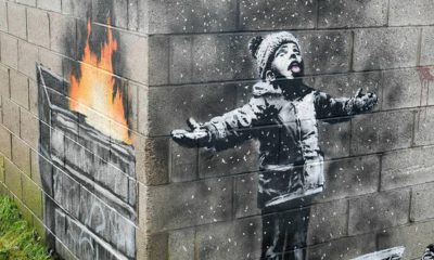 Photo of mural by Banksy on the side of a garage