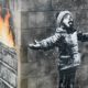 Photo of mural by Banksy on the side of a garage