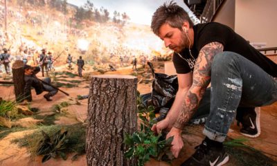 Photo of a worker putting final touches on diorama
