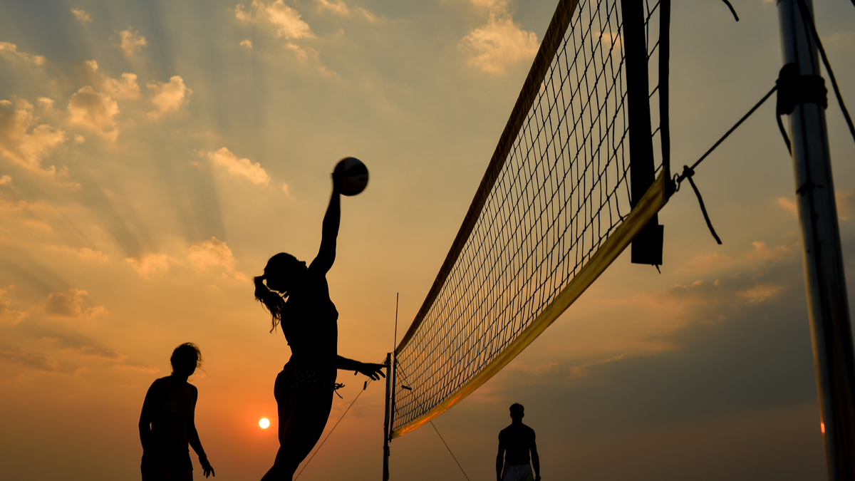 Photo of women playing beach volleyball