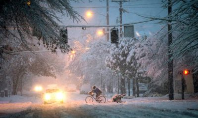 Photo of man riding a bicycle through the snow in Oregon