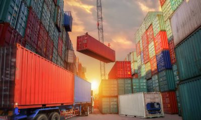 Photo of industrial crane loading container to truck