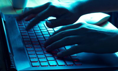 Photo of a hacker typing on a laptop