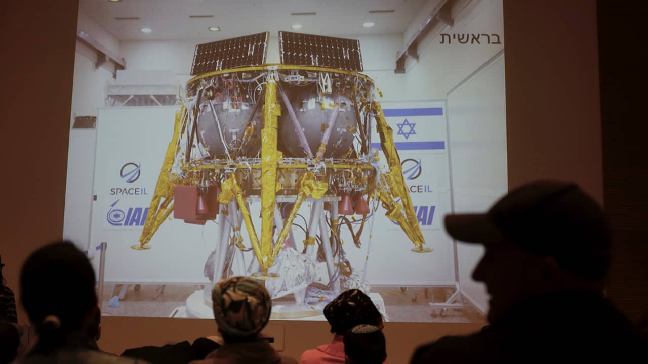 Photo of people watching a live broadcast of the SpaceL spacecraft