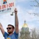 Photo of Chris Olson holding a sign in Denver