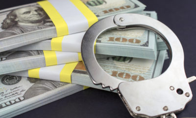 Photo of handcuffs and $100 bills