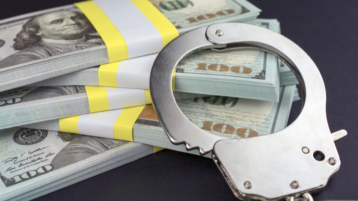 Photo of handcuffs and $100 bills