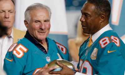 Miami Dolphins player Nick Buoniconti (85) is presented a football by former player and current Dolphins senior vice president of special projects and alumni relations, Nat Moore