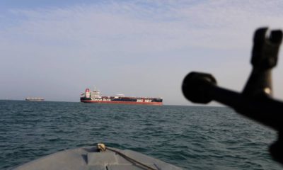 Photo of Iranian Revolutionary Guard pointing weapon at British warship