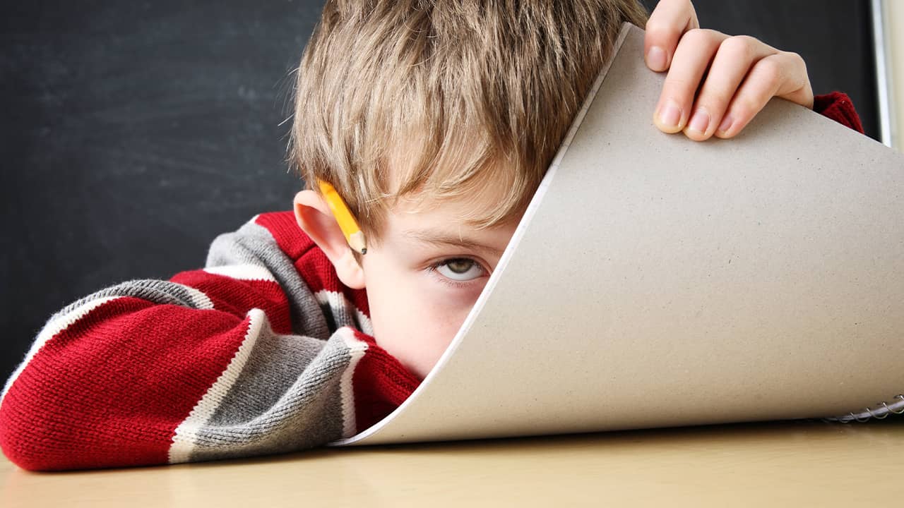 Photo of a bored student hiding his face