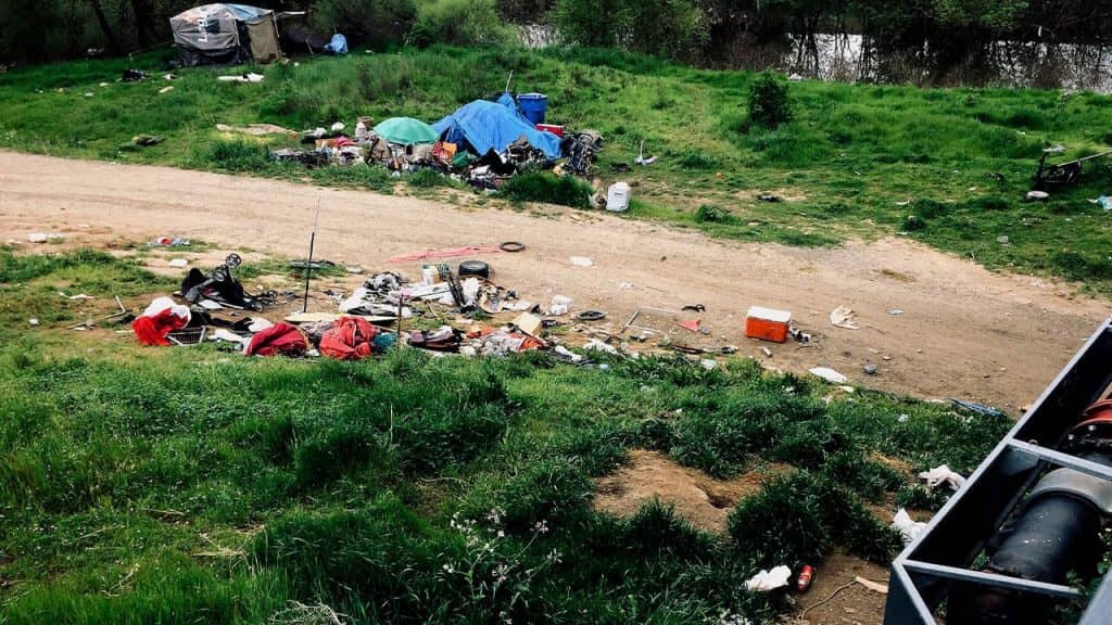 Photo of trash and a homeless tent in Sacramento