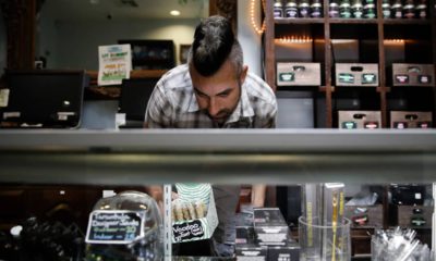 Photo of Jerred Kiloh stocking shelves with cannabis products