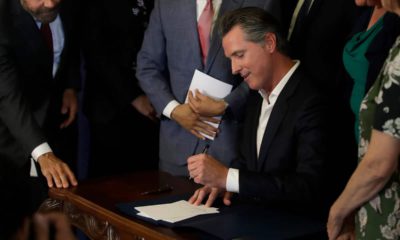 Photo of Gavin Newsom signing AB1482