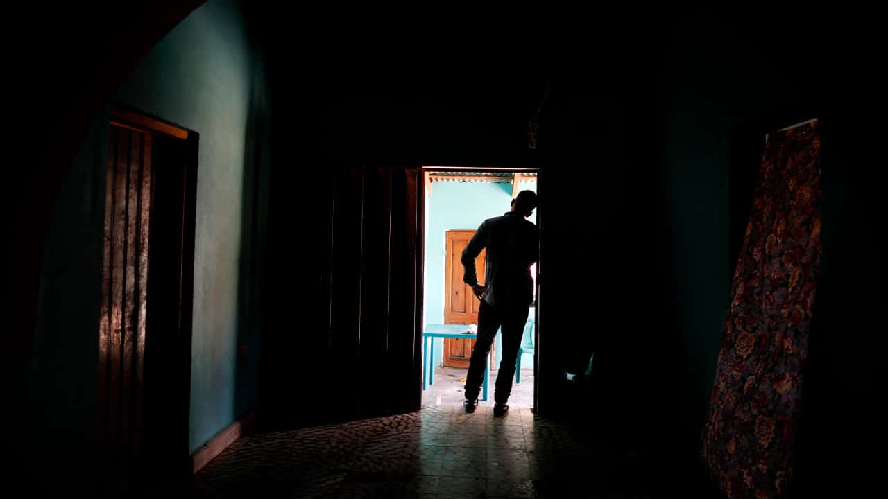 Photo of Honduran father standing at his home