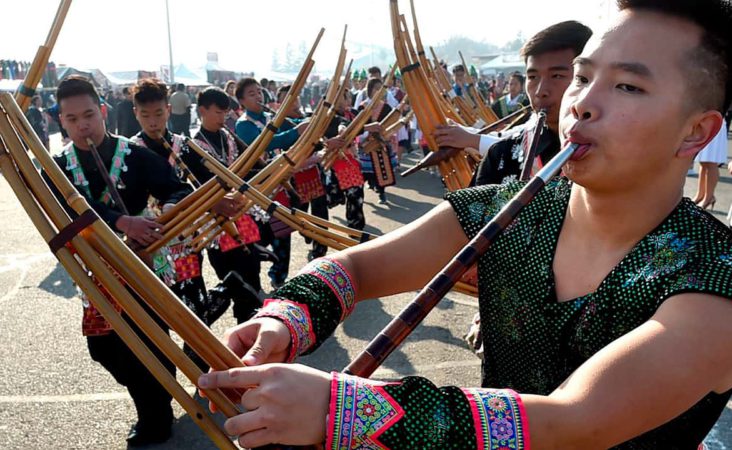 In this photo taken Dec. 26, 2017, Phia Cha, right, and other members of the Suab Hmoob Txuj Ci group perform on the traditional Hmong instrument, the qeej, during the grand opening parade during the Hmong Cultural New Year Celebration at the fairgrounds in Fresno, Calif. The country's small Hmong American population is reeling from the shooting deaths of four men at a backyard party at a Northern California central valley city. Fresno hosts a week-long New Year's party every year that draws tens of thousands of Hmong from around the country, complete with colorful traditional dress, song, and sports games. (John Walker/The Fresno Bee via AP)