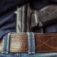 Photo of a man with a gun tucked under his belt in back