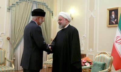 Photo of President Hassan Rouhani, right, shakes hands with Omani Minister of State for Foreign Affairs Yusuf bin Alawi