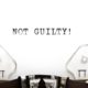 the words "Not Guilty!" on white paper in a typewriter