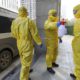 Photo of funeral workers disinfecting themselves