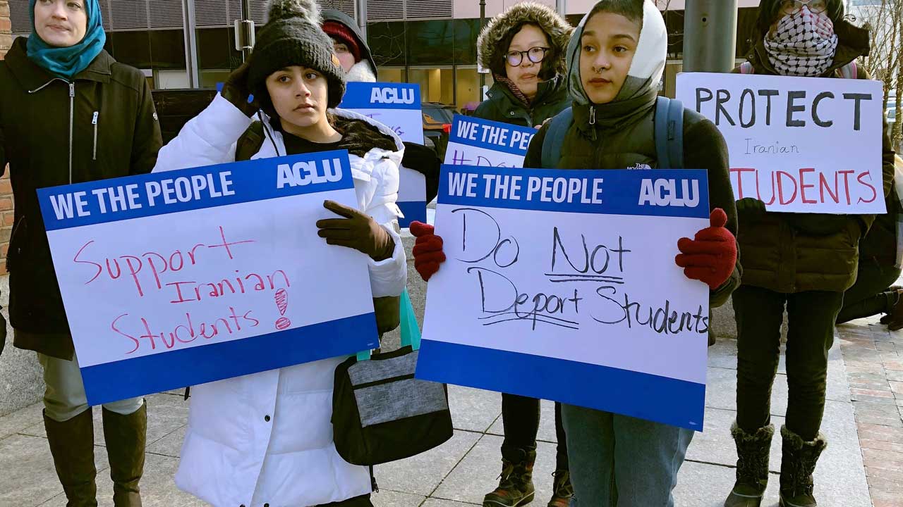 Photo of protester standing outside the federal courthouse where a hearing was scheduled for Northeastern University student Shahab Dehghani