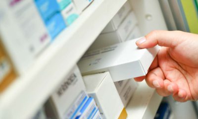 Photo of a pharmacist's hand holding a medicine box