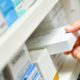 Photo of a pharmacist's hand holding a medicine box
