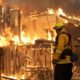 Photo of a firefighter monitoring a house burning in Santa Rosa, Calif.