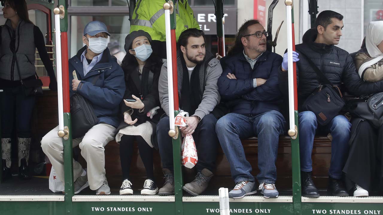 San Francisco cable car riders wearing masks.