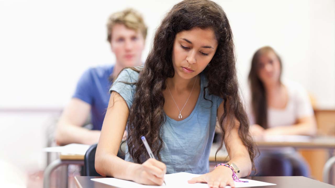 Student in classroom taking notes