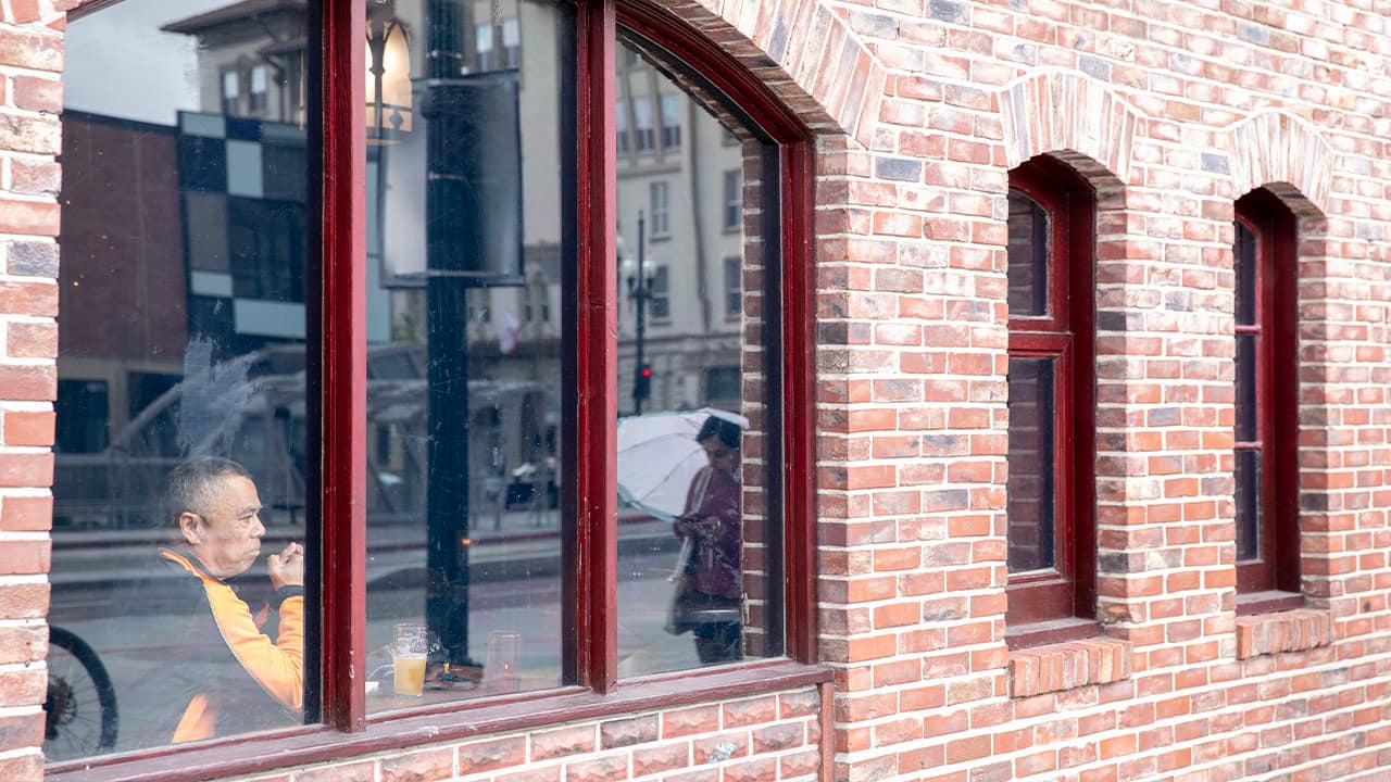 Photo of a man looking out the window of a restaurant