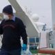 Photo of a cruise ship worker cleaning a railing